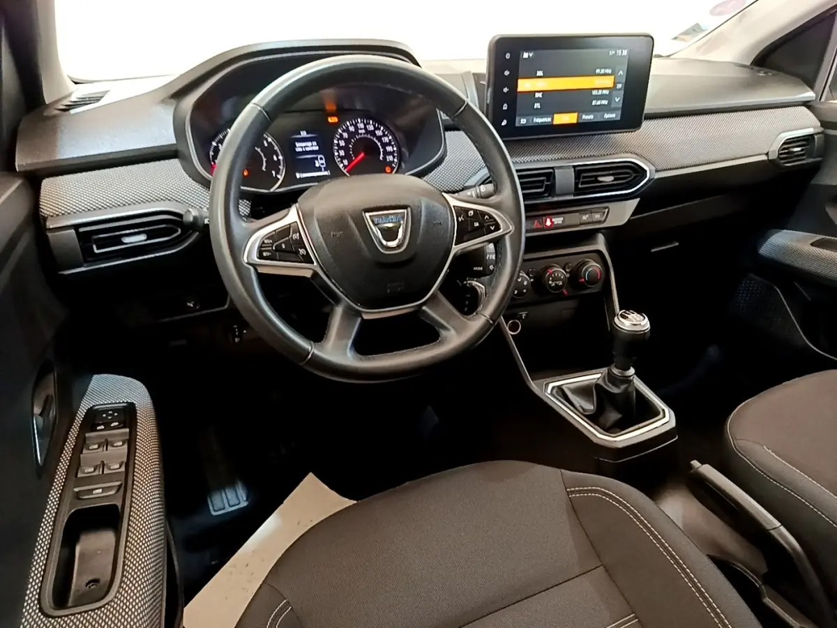 Vue intérieure avant de la Dacia Sandero Confort TCe 90 2022, tableau de bord avec écran tactile et volant multifonctions.