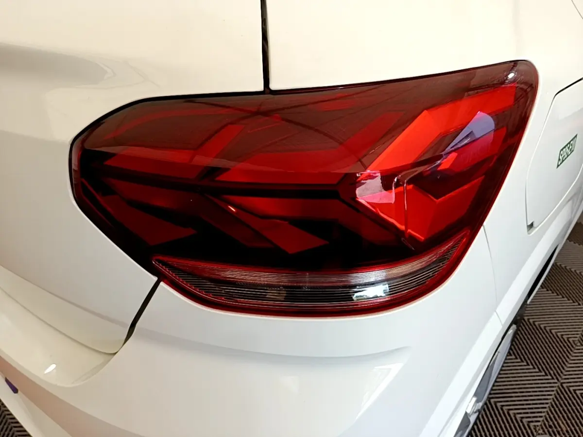 Gros plan sur le feu arrière droit rouge d’une Dacia Sandero Confort TCe 90 blanche, vue arrière côté droit.