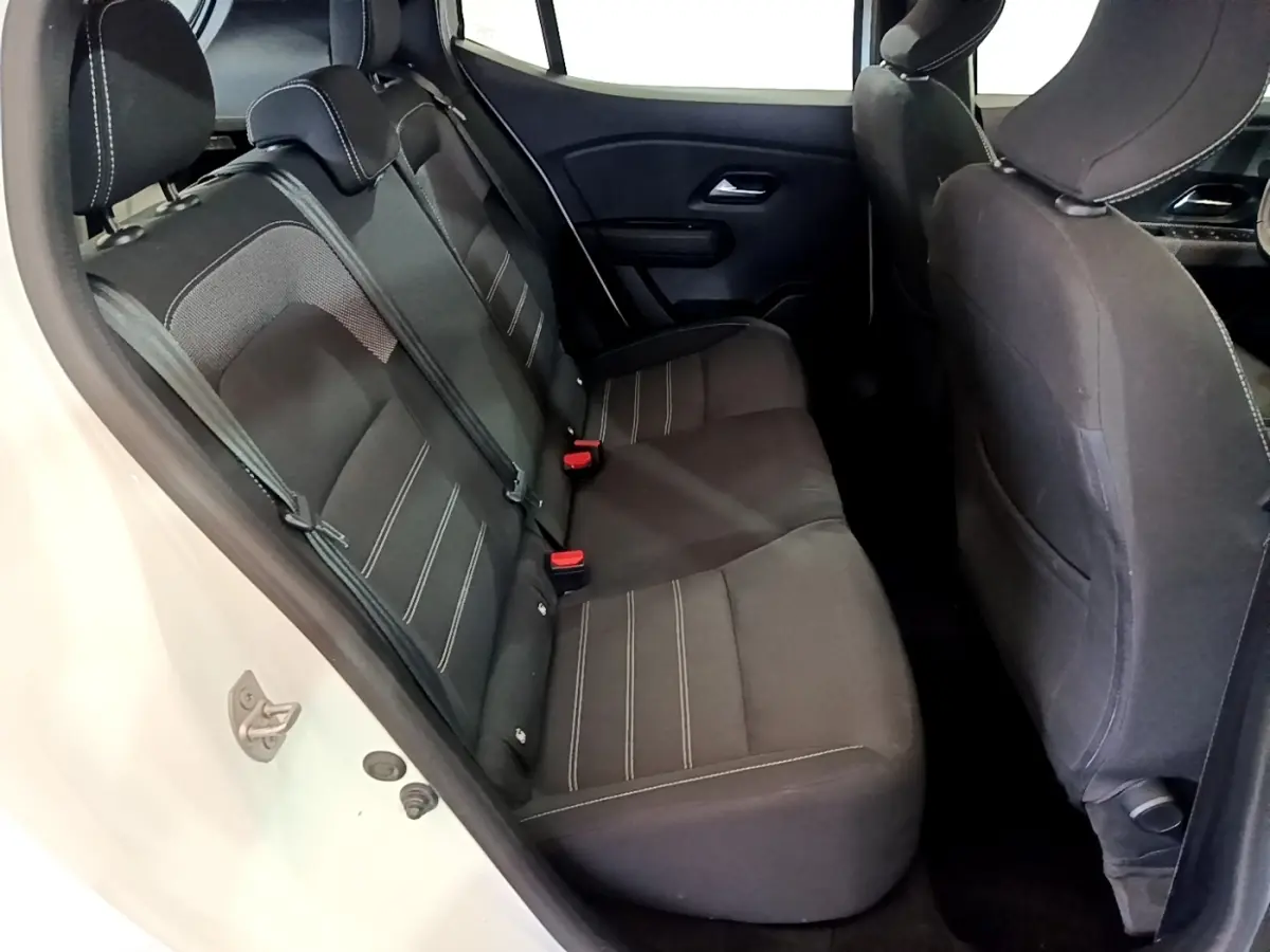 Vue intérieure côté gauche sur la banquette arrière noire avec surpiqûres blanches de la Dacia Sandero blanche.
