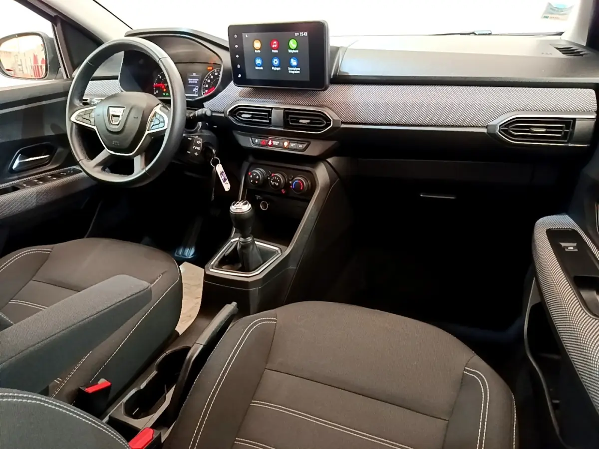 Vue intérieure avant droite de la Dacia Sandero Confort TCe 90 2022, avec tableau de bord moderne et écran tactile central.