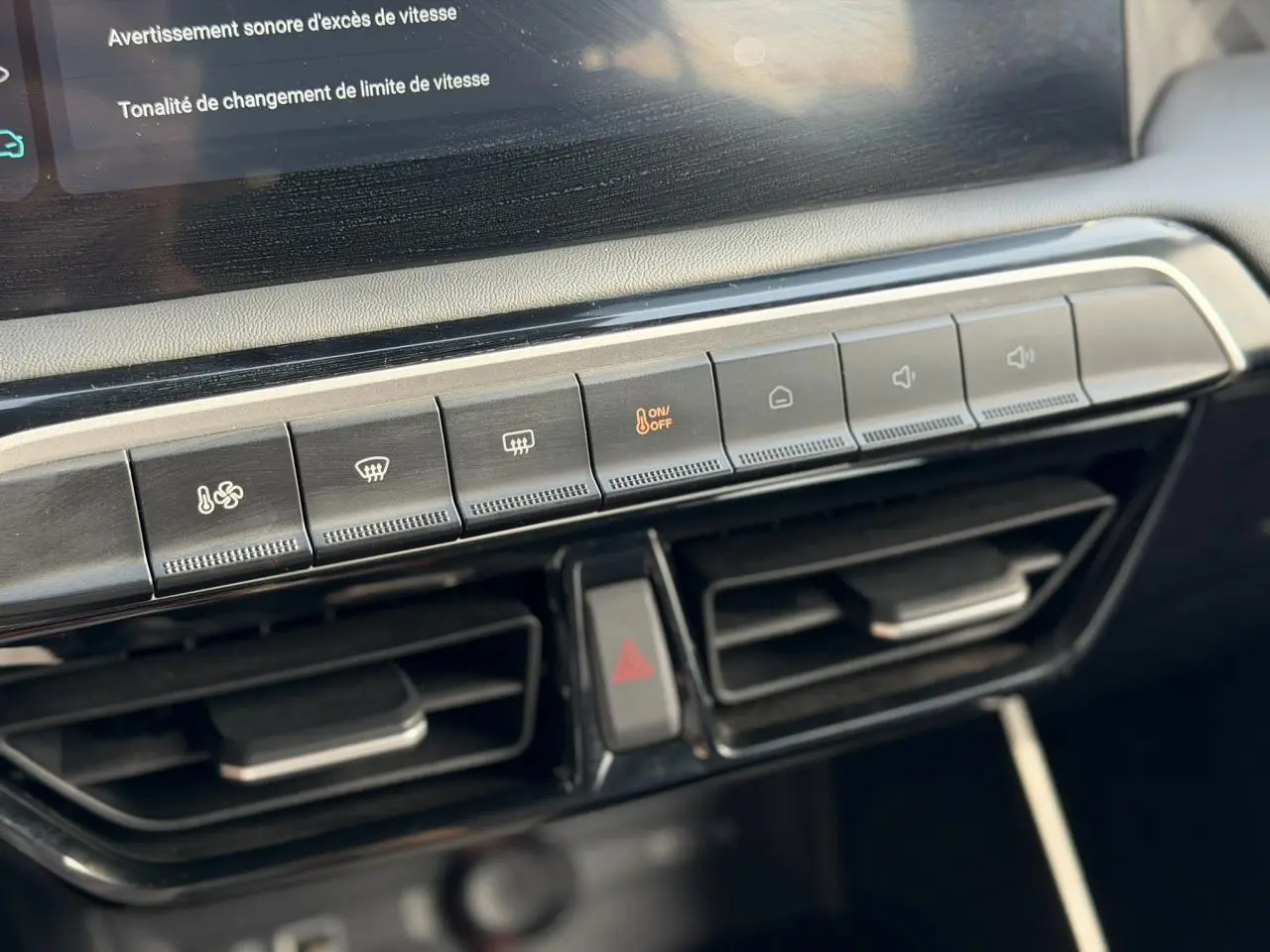 Gros plan sur la console centrale du MG3 2025, boutons de climatisation et ventilation avec écran tactile partiel visible.