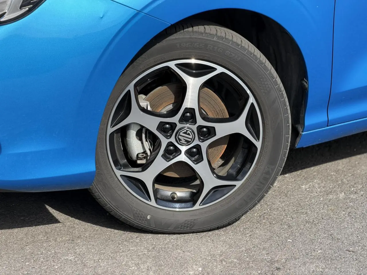 Gros plan sur la roue avant gauche avec jante alliage 16'' noire et argentée du MG3 bleu Como 2025.