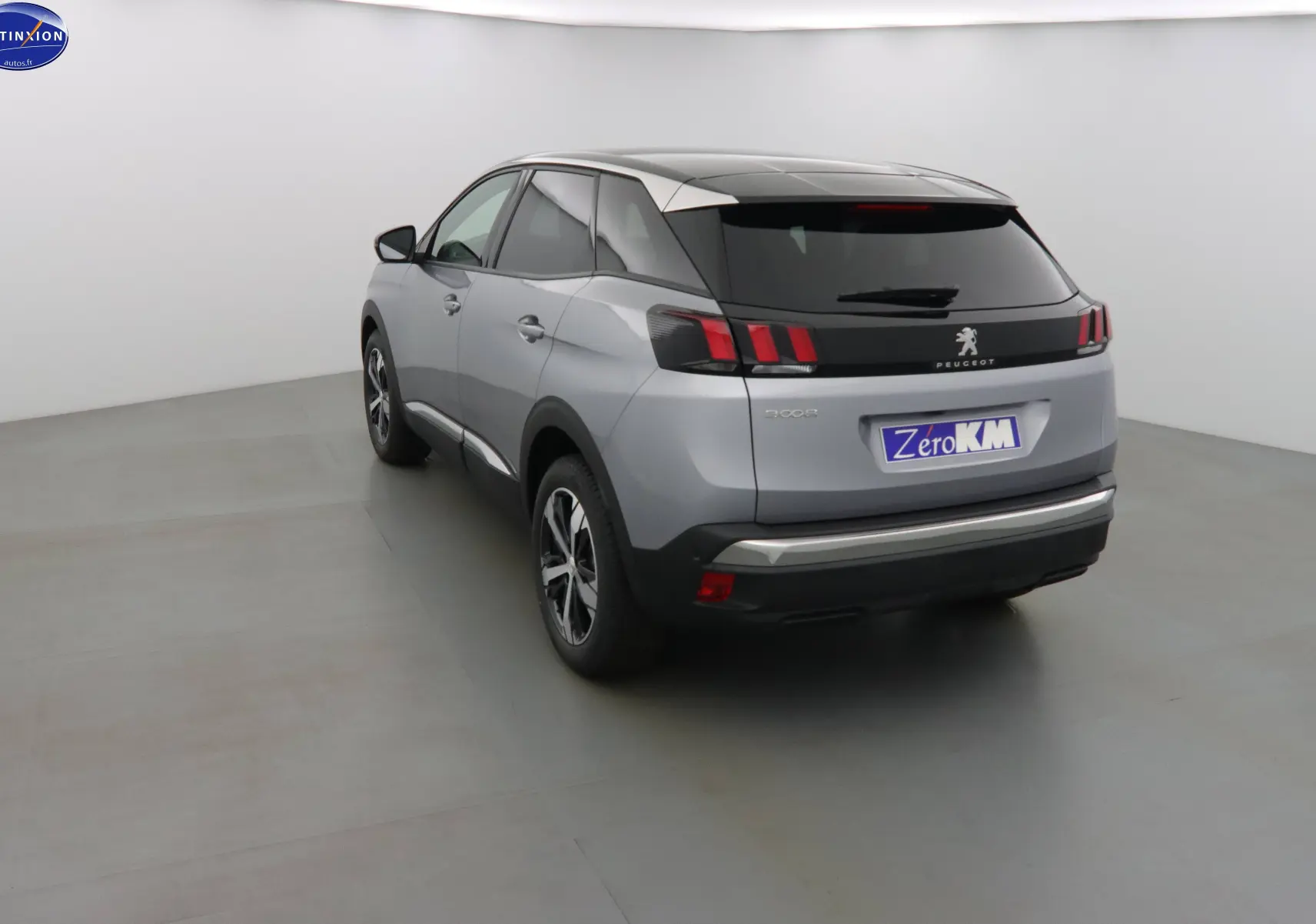 Vue 3/4 arrière droite d'un Peugeot 3008 gris Artense métallisé avec feux arrière à griffes rouges et toit noir.