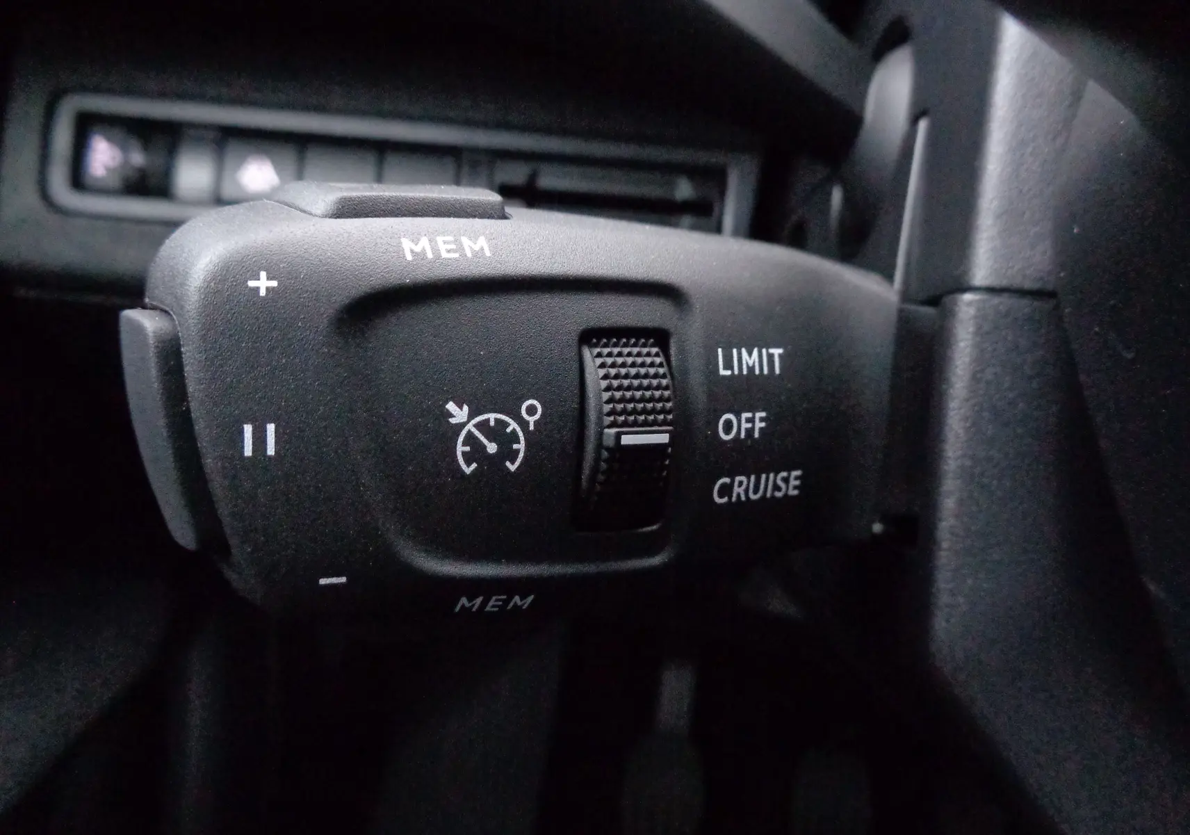 Gros plan sur la commande de régulateur de vitesse noire à gauche du volant du Peugeot 3008 gris Artense 2023.