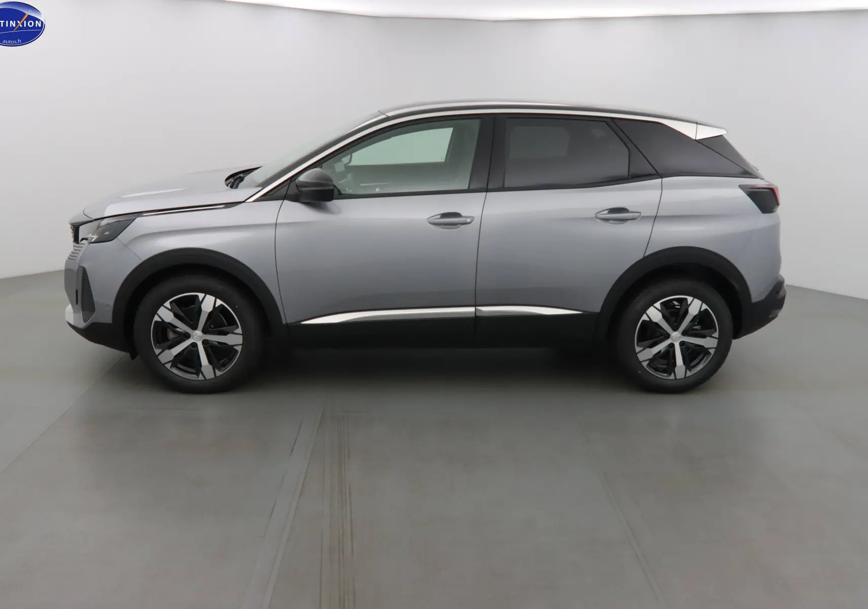 Profil côté gauche du Peugeot 3008 2023 gris Artense métallisé avec toit noir et jantes bi-ton.