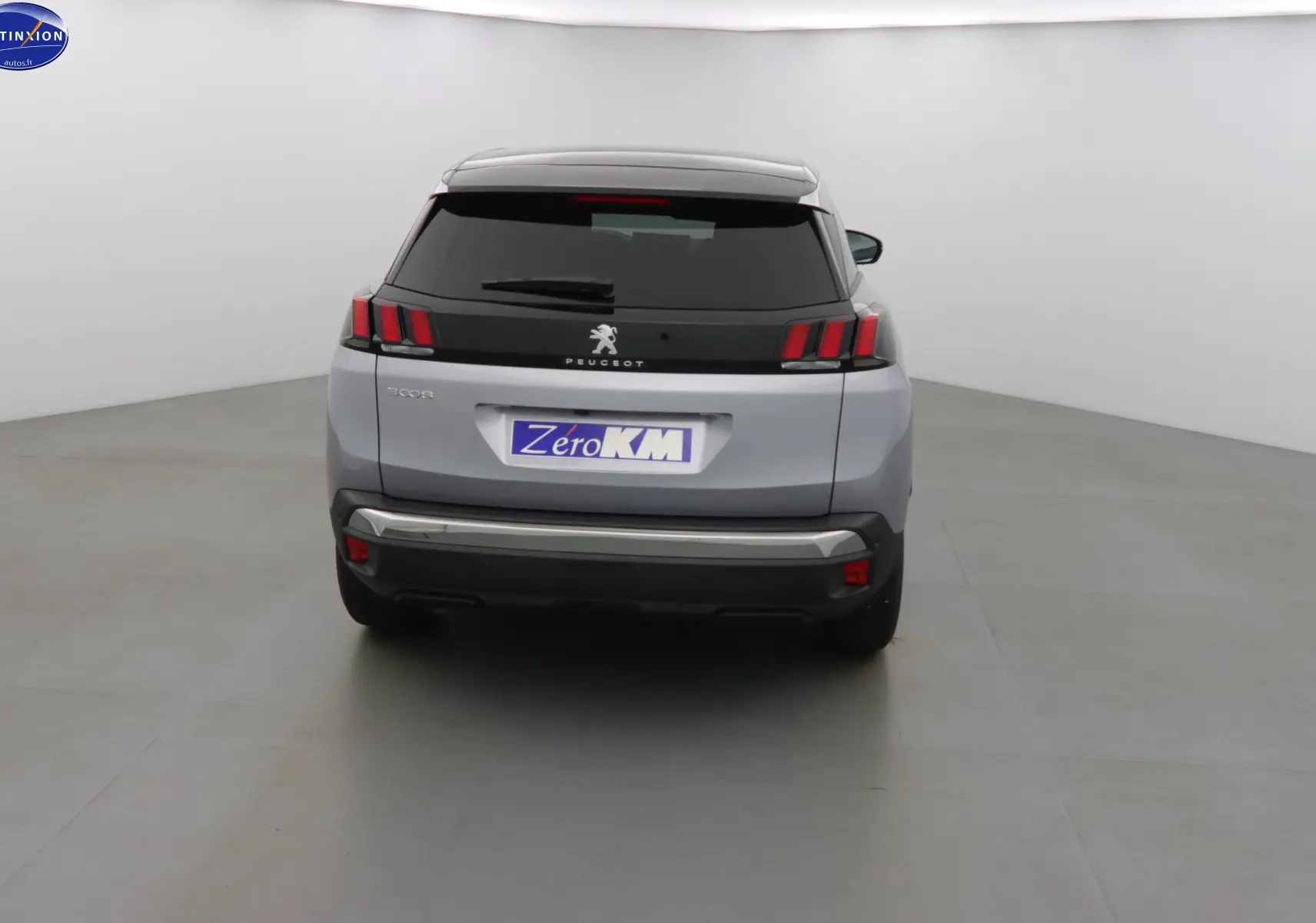 Vue arrière d'un Peugeot 3008 gris Artense métal 2023 avec feux arrière à trois griffes distinctives.
