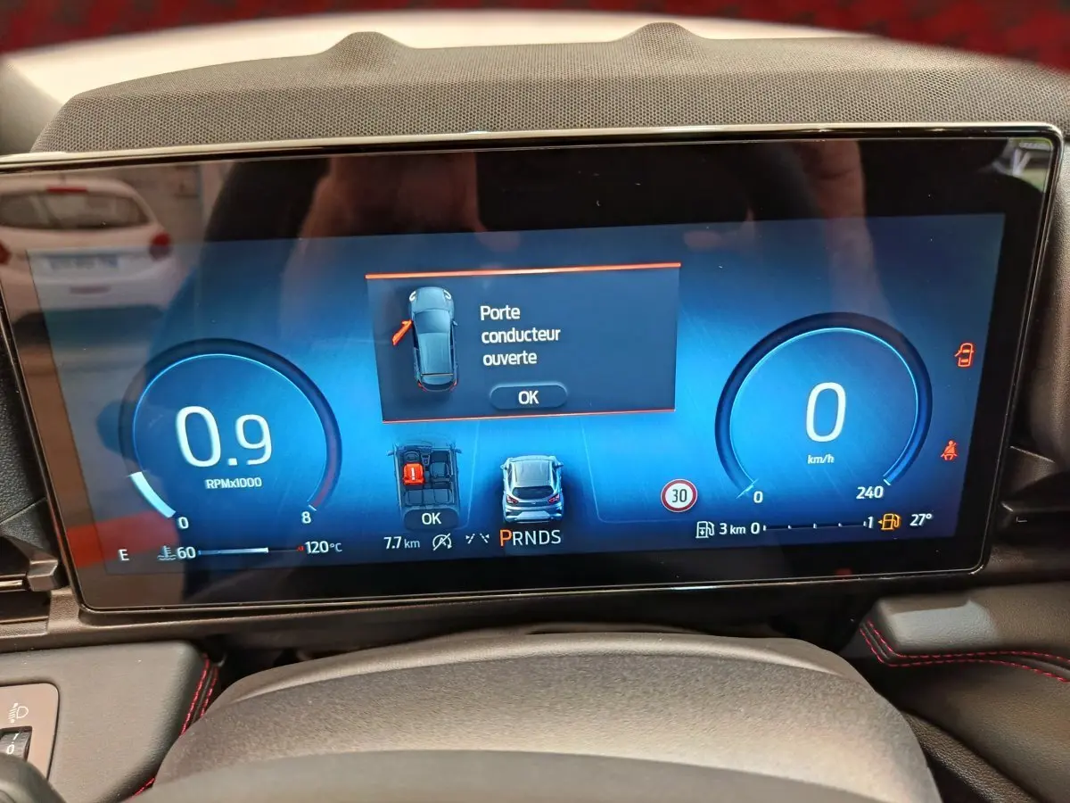 Affichage numérique du combiné d'instruments du Ford Puma bleu 2025, indiquant porte conducteur ouverte et vitesse à 0 km/h.