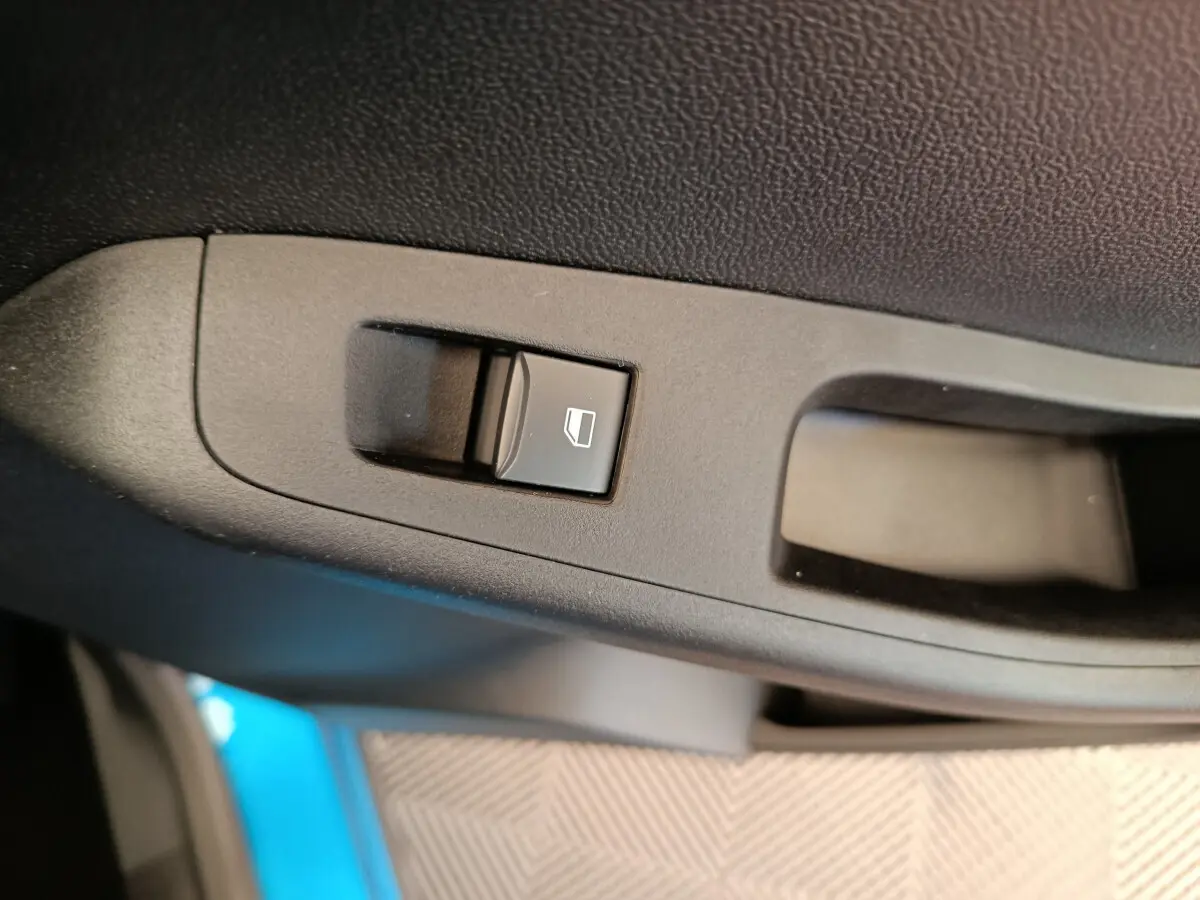 Bouton de commande de lève-vitre sur la porte intérieure côté conducteur du Ford Puma bleu 2025.
