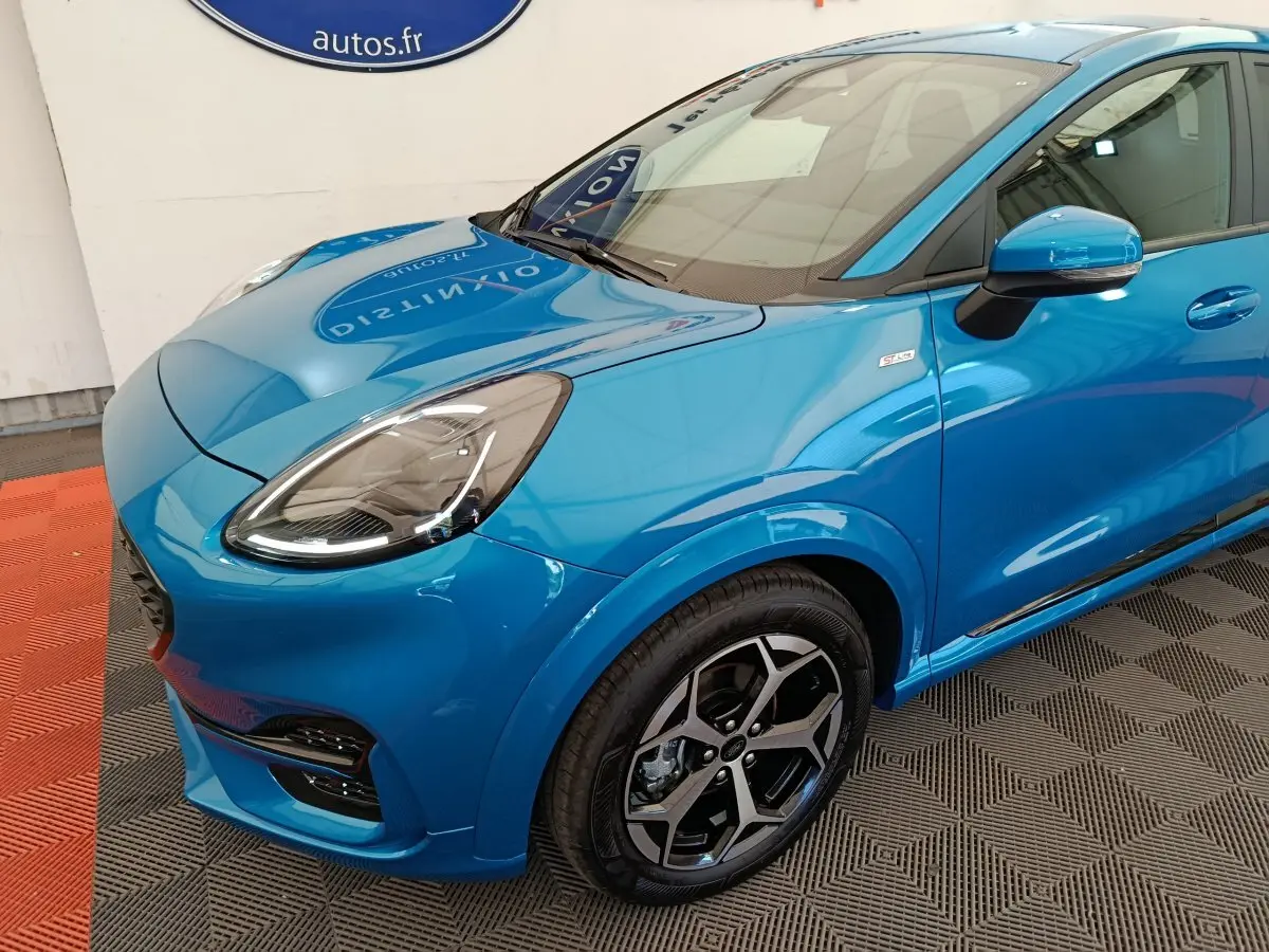 Vue 3/4 avant droit d'une Ford Puma bleu vif avec jantes alliage et badge ST-LINE sur aile avant.