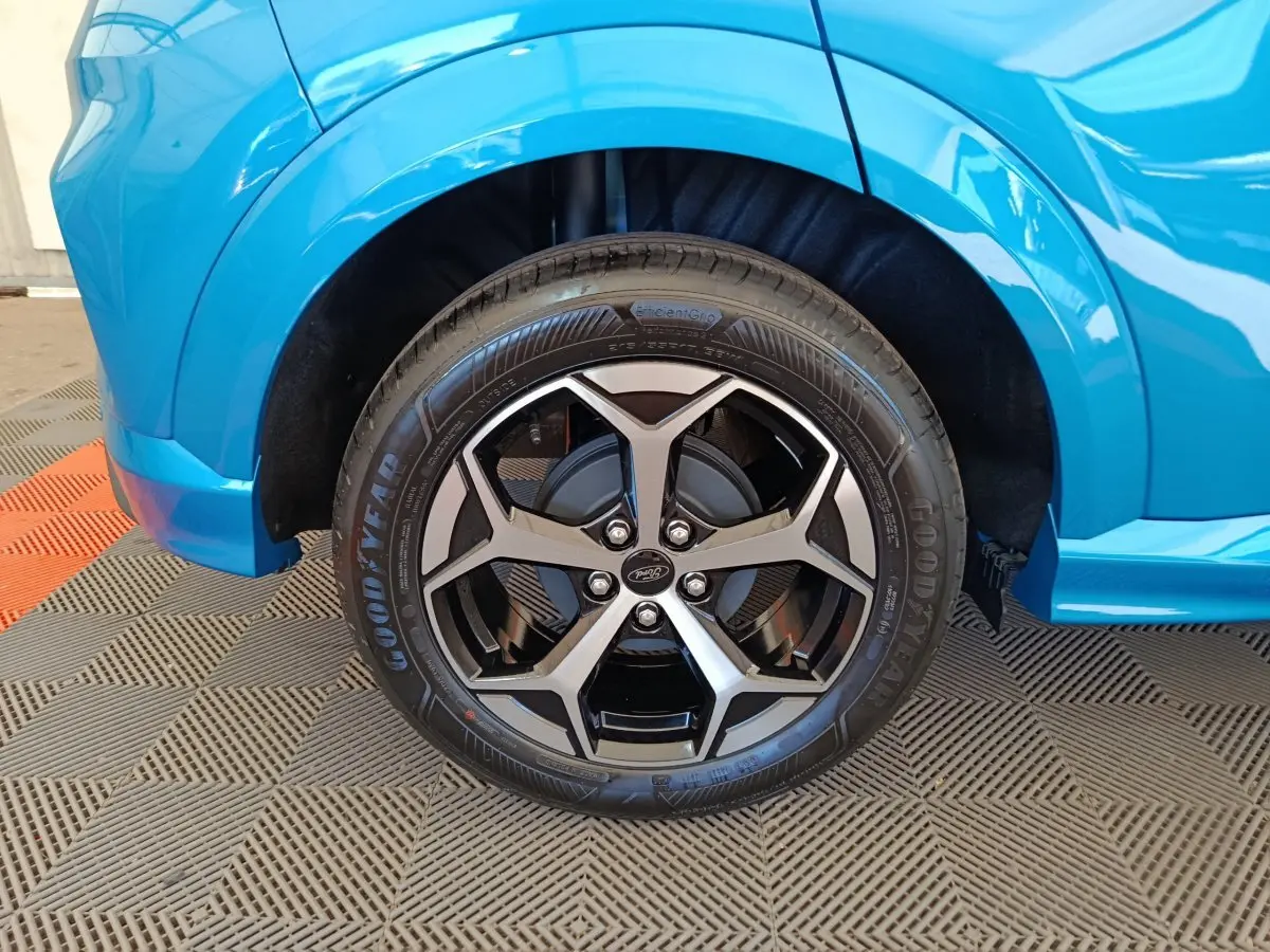 Gros plan sur la roue avant droite du Ford Puma bleu 2025 avec jante alliage noir et argentée design moderne.