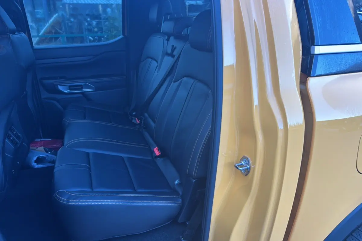 Vue intérieure côté gauche sur les sièges arrière en cuir noir du Ford Ranger 2025 Cyber orange Wildtrak Plus hybride.