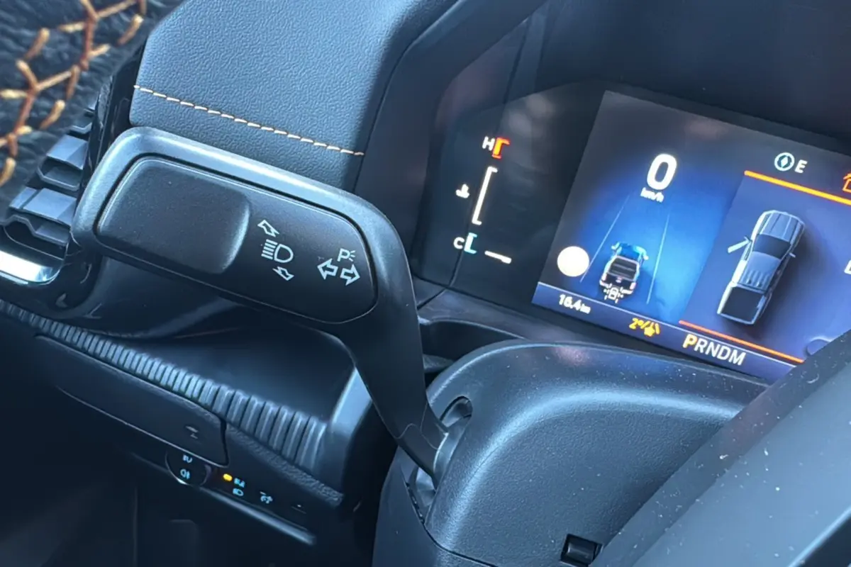 Gros plan sur le levier de clignotant et le tableau de bord numérique du Ford Ranger 2025 hybride.