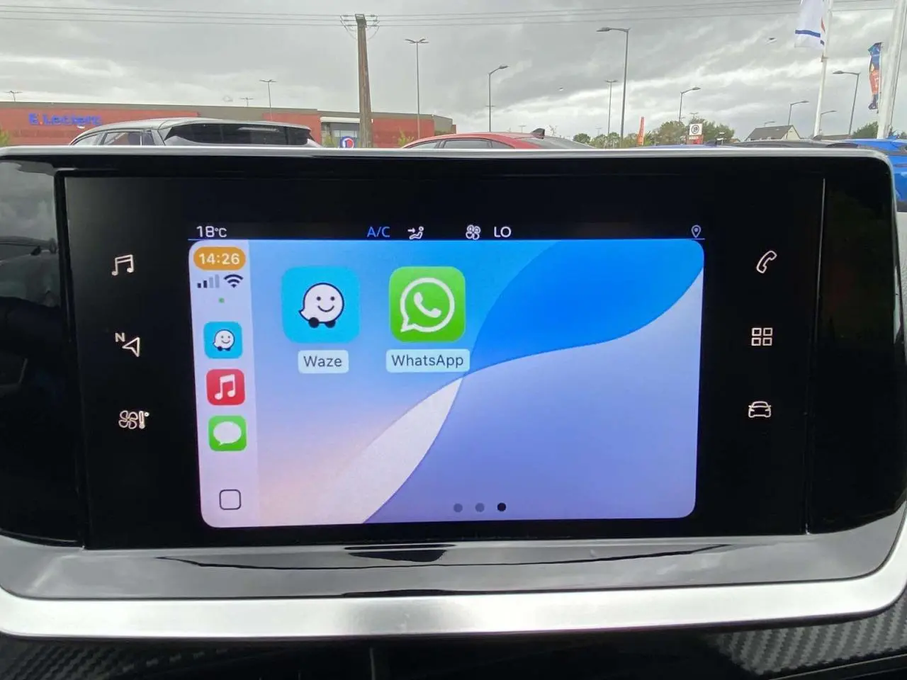 Écran tactile 7 pouces du tableau de bord de la Peugeot 208 1.2i PureTech 2020 affichant Waze et WhatsApp.