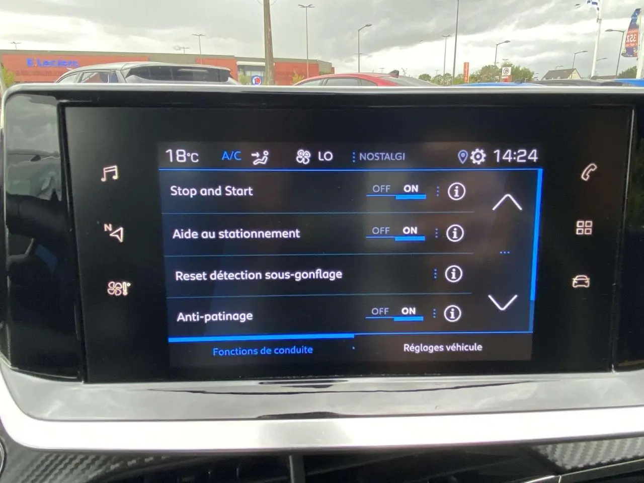 Écran tactile central de la Peugeot 208 bleu affichant les réglages d'aide à la conduite, vue frontale intérieure.