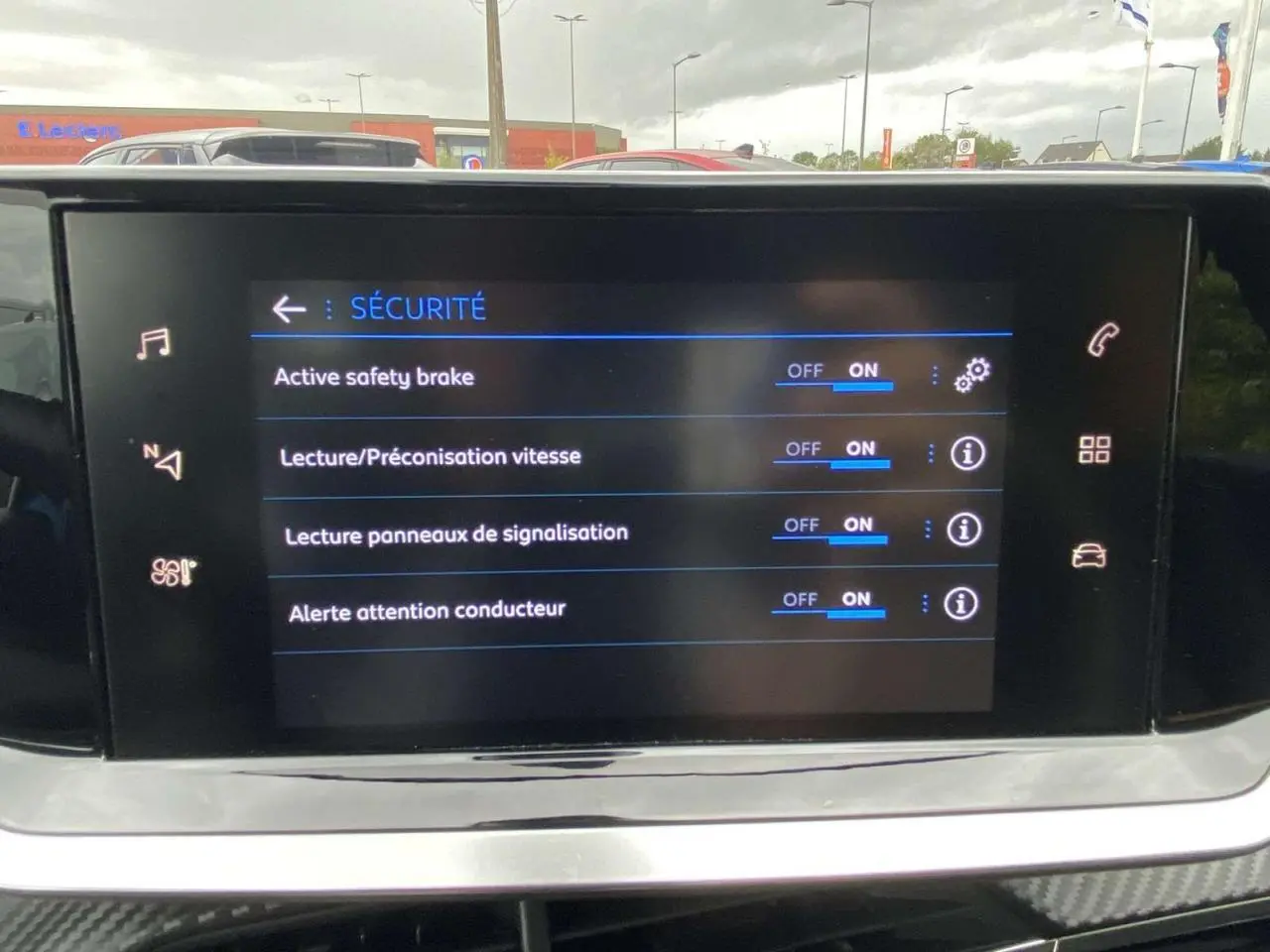 Écran tactile intérieur de la Peugeot 208 bleu affichant les options de sécurité activées