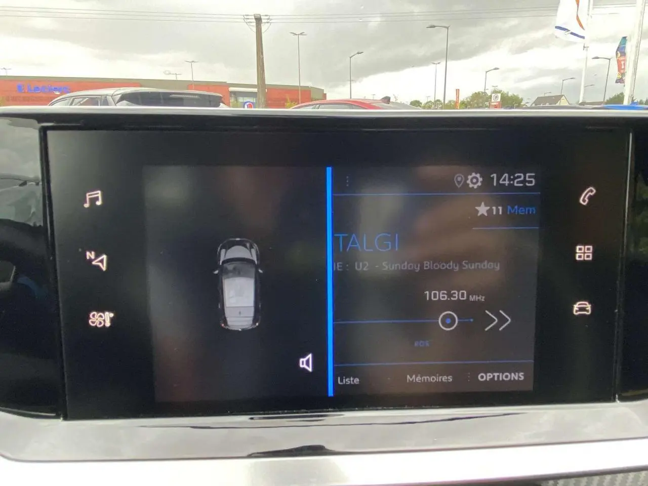 Écran tactile 7 pouces de la Peugeot 208 2020 affichant la radio et la vue du véhicule en stationnement.