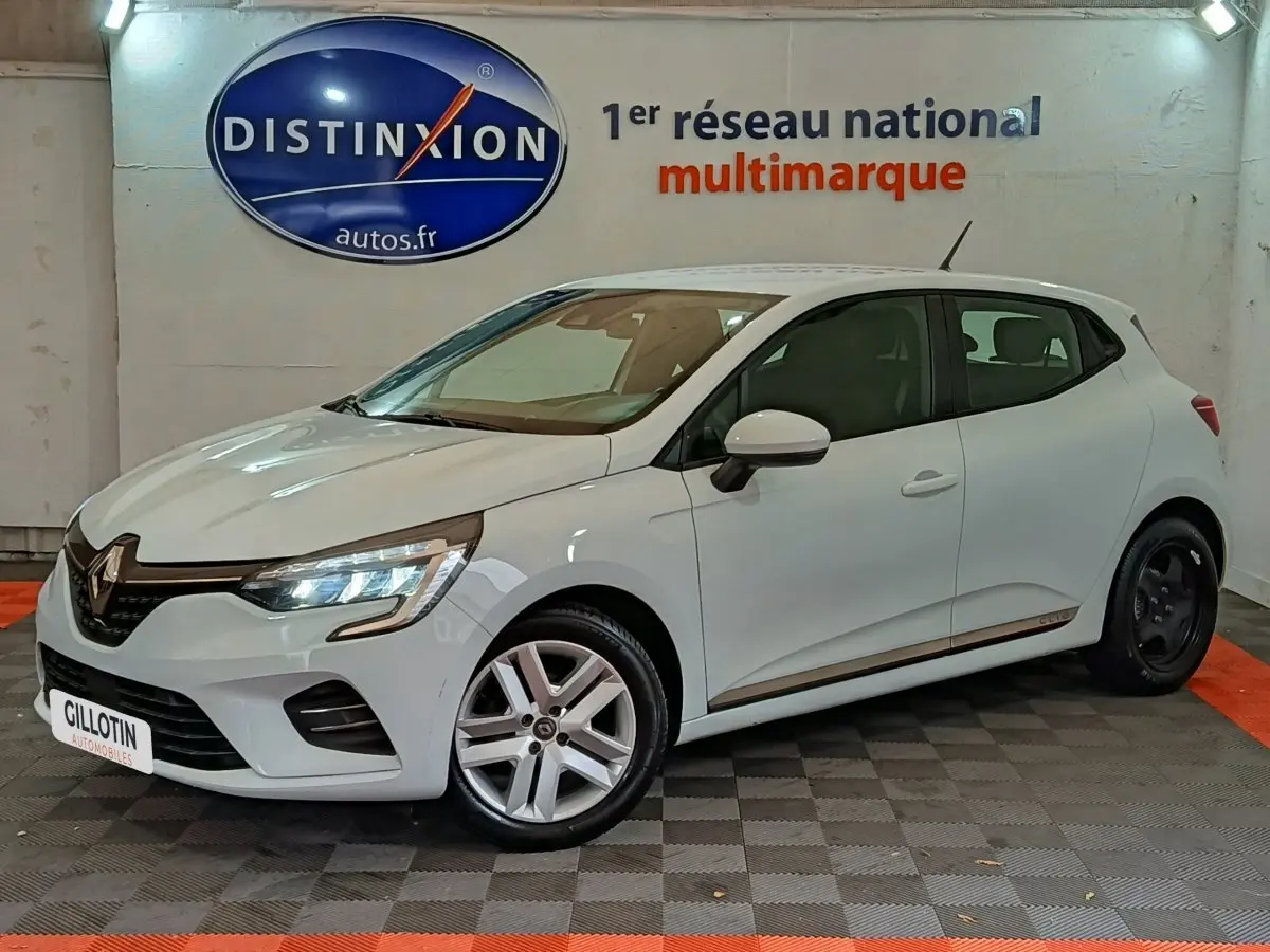 Renault Clio Business TCe 90 blanche vue 3/4 avant droit en intérieur avec jantes différentes avant et arrière.