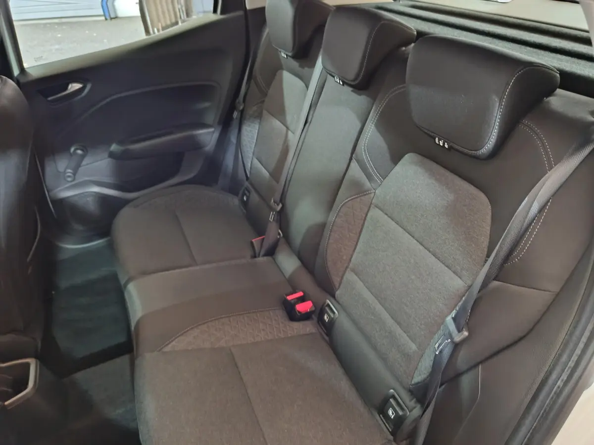 Vue intérieure sur la banquette arrière noire de la Renault Clio Business TCe 90, avec ceintures et appuie-têtes visibles.