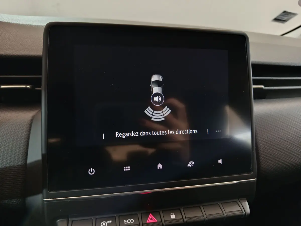 Écran tactile central affichant l'aide au stationnement dans l'habitacle de la Renault Clio Business blanc.