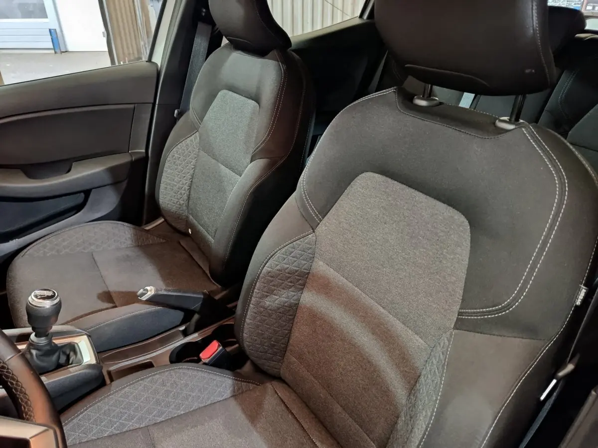 Vue intérieure rapprochée des sièges avant en tissu gris et noir de la Renault Clio Business TCe 90 2021.