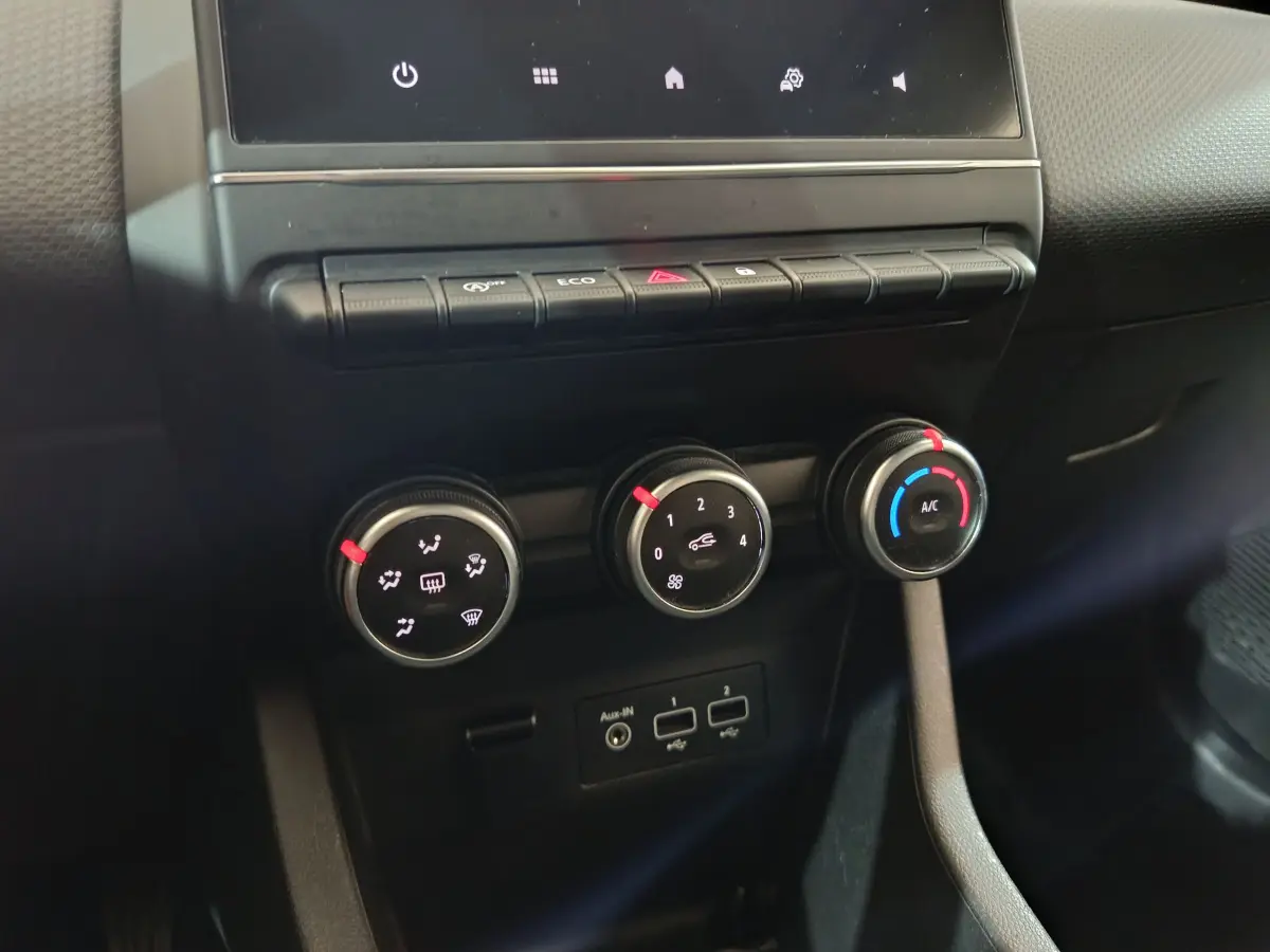 Gros plan sur les commandes de climatisation et connectiques USB de la Renault Clio Business TCe 90 blanche, vue intérieure centrale.