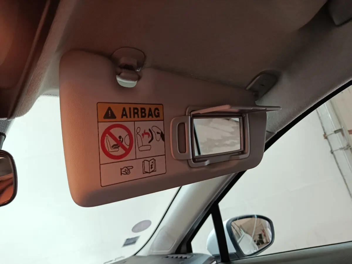 Détail du pare-soleil côté conducteur avec miroir ouvert dans l'habitacle clair d'une Renault Clio blanche 2021.