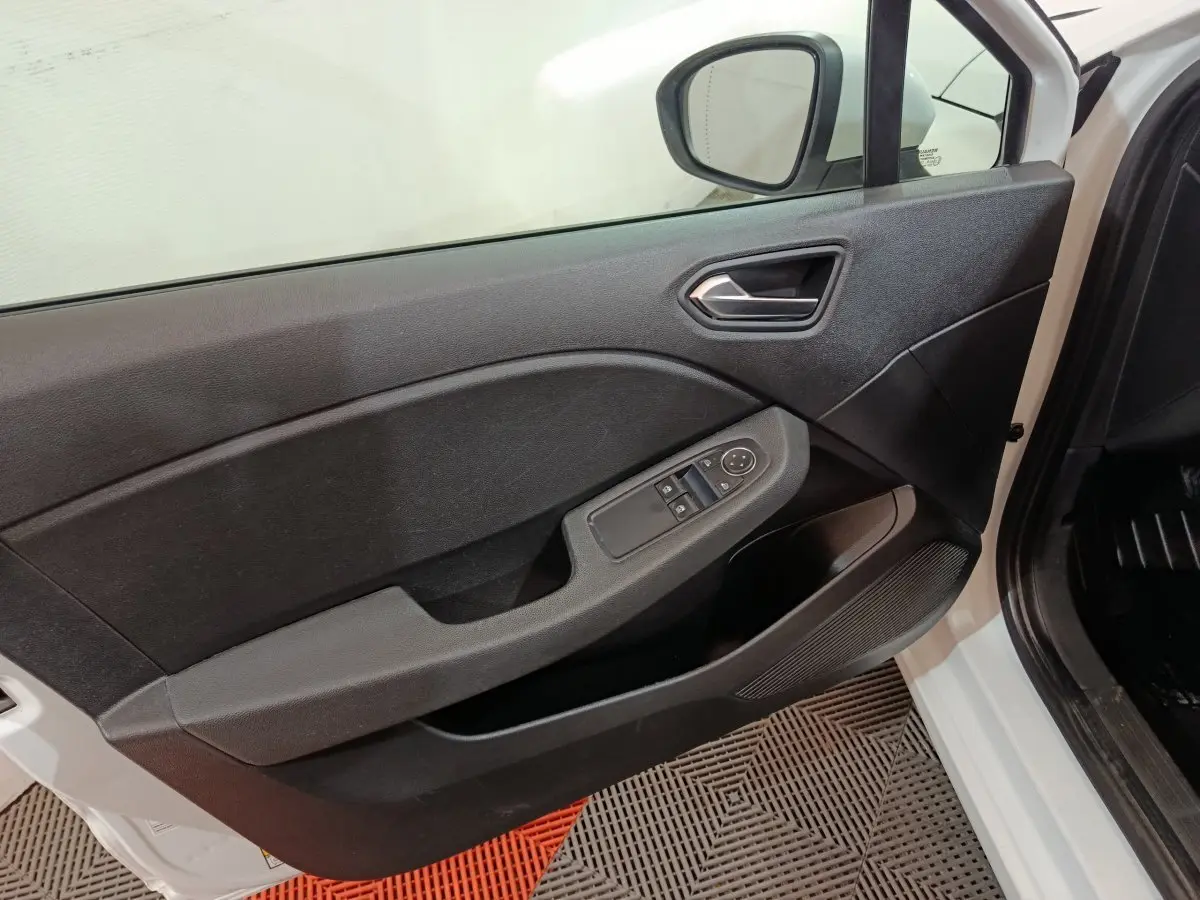 Vue côté gauche de la porte avant blanche d'une Renault Clio Business TCe 90 avec commandes de vitres et rétroviseur.