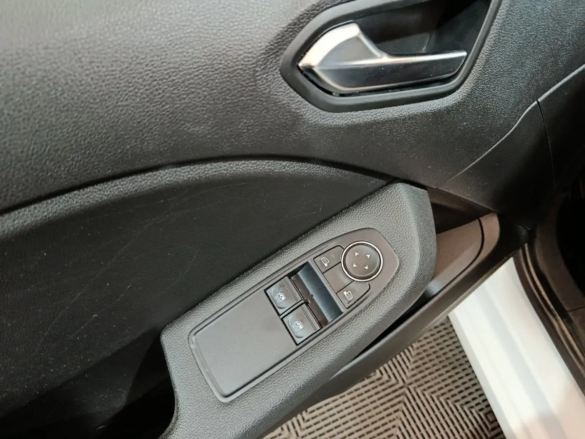 Détail de la porte côté conducteur de la Renault Clio Business blanche 2021 avec commandes électriques des vitres et rétroviseurs.