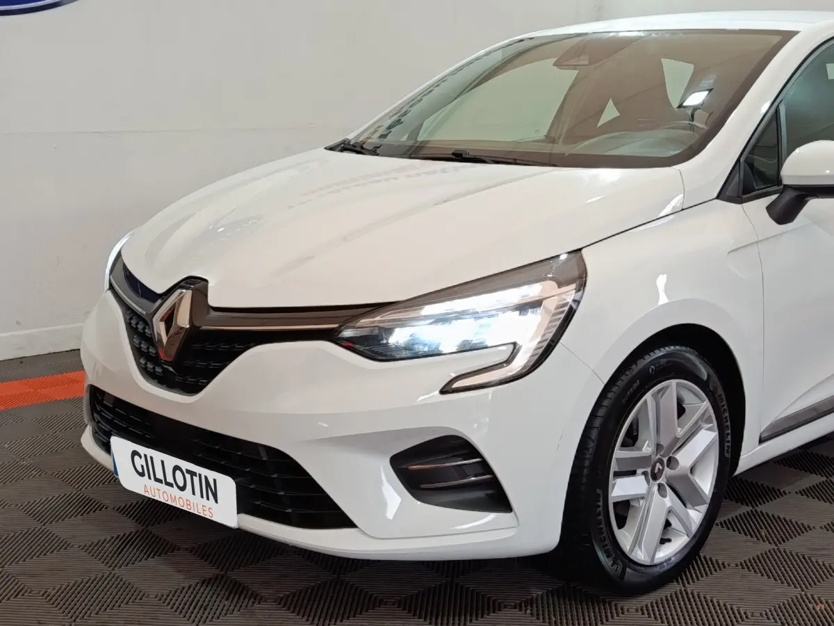 Renault Clio Business TCe 90 blanc vue 3/4 avant droit, feux LED allumés et jantes alliage visibles.
