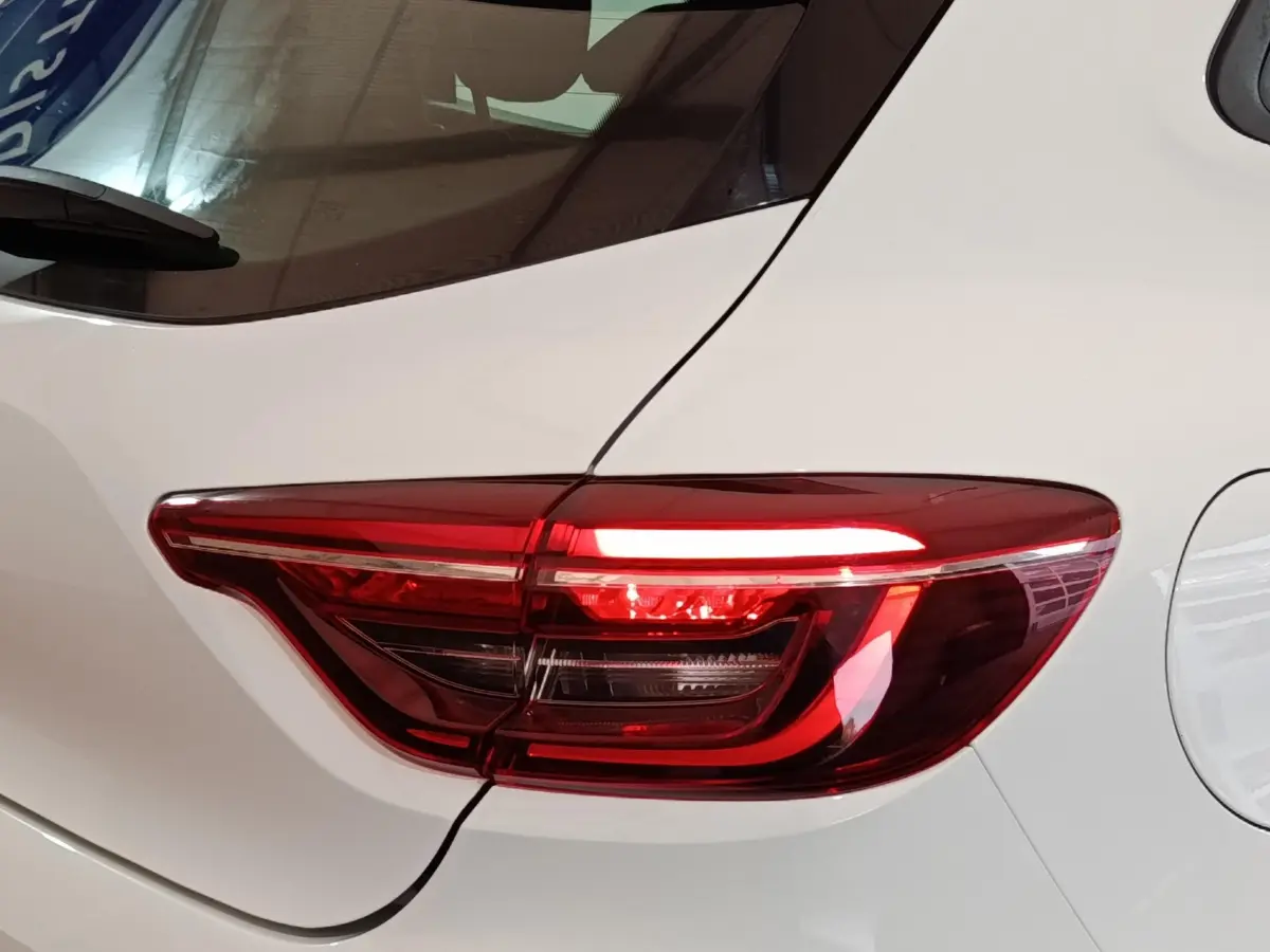 Gros plan sur le feu arrière droit rouge d'une Renault Clio Business blanche de 2021, avec la portière visible.