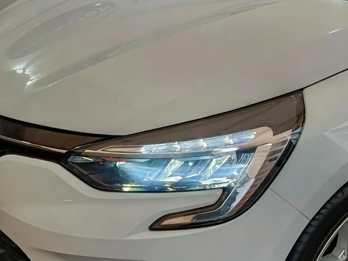 Gros plan sur le phare avant droit LED d'une Renault Clio Business TCe 90 blanche de 2021.