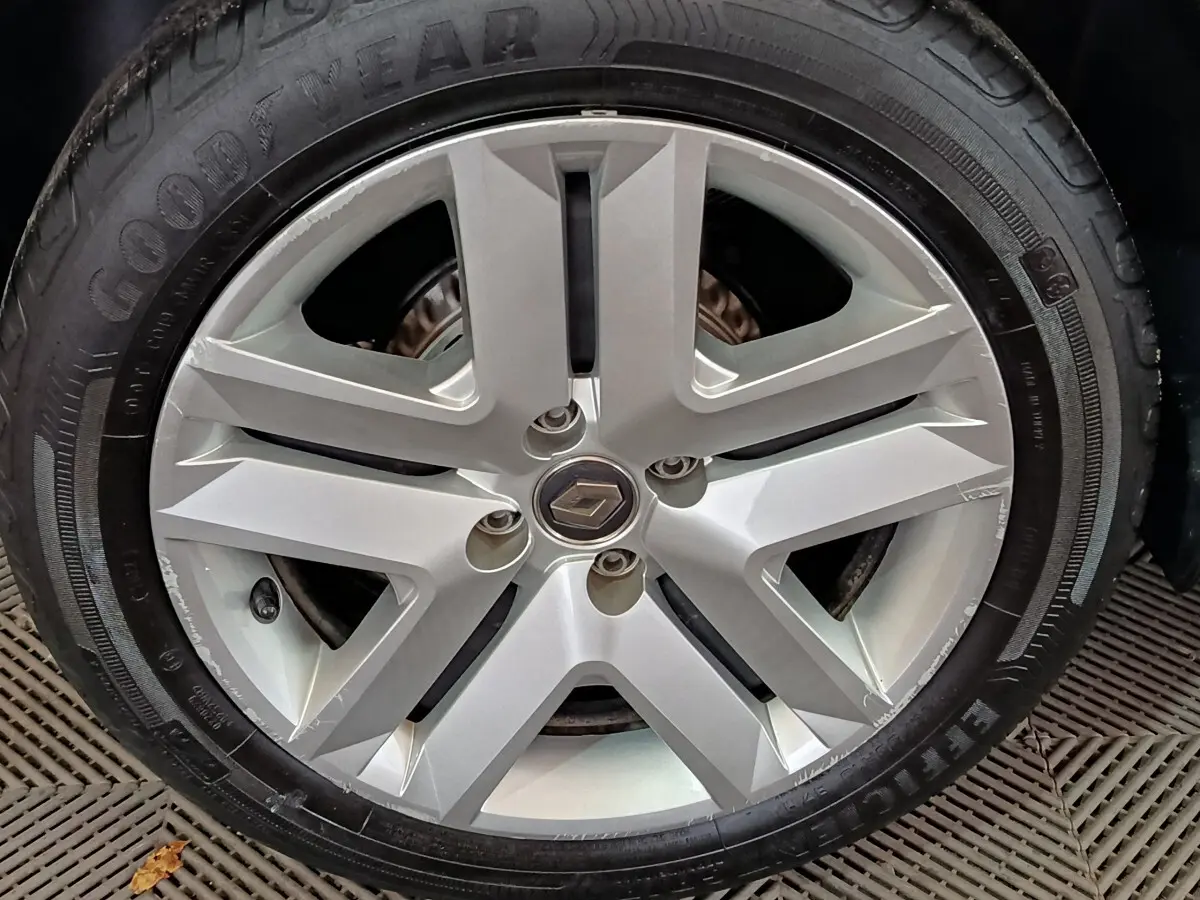 Gros plan sur la jante alliage argentée avec logo Renault au centre d'une Renault Clio blanche de 2021.