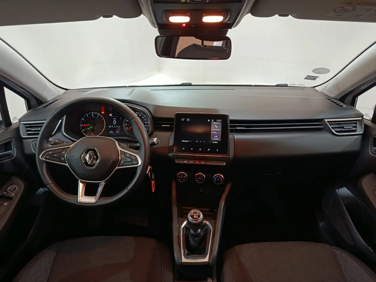 Intérieur de Renault Clio Business TCe 90 2021, vue frontale du tableau de bord avec écran tactile et volant cuir noir.