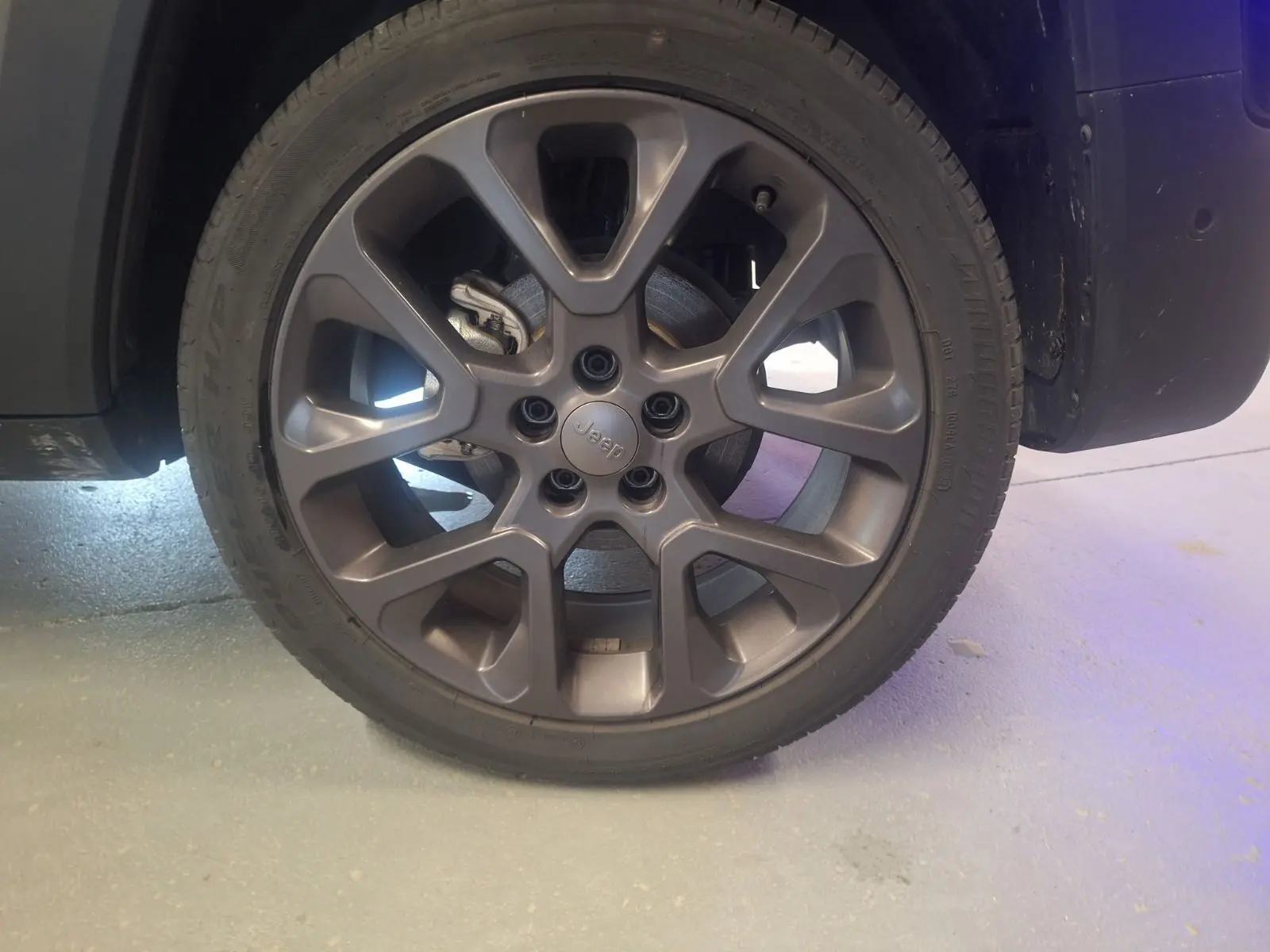 Gros plan sur la roue avant droite du Jeep Renegade noir 2024, mettant en valeur la jante alliage 19 pouces au design moderne.