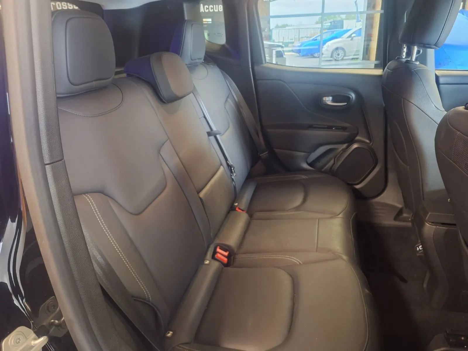 Vue intérieure côté droit des sièges arrière en cuir noir du Jeep Renegade 2024, avec appuie-têtes et ceintures visibles.