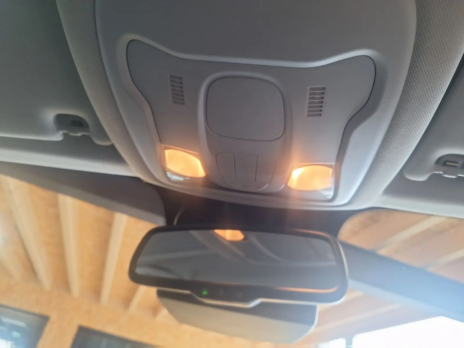 Vue intérieure du plafonnier avec éclairage allumé et rétroviseur d'une Jeep Renegade noire 2024.