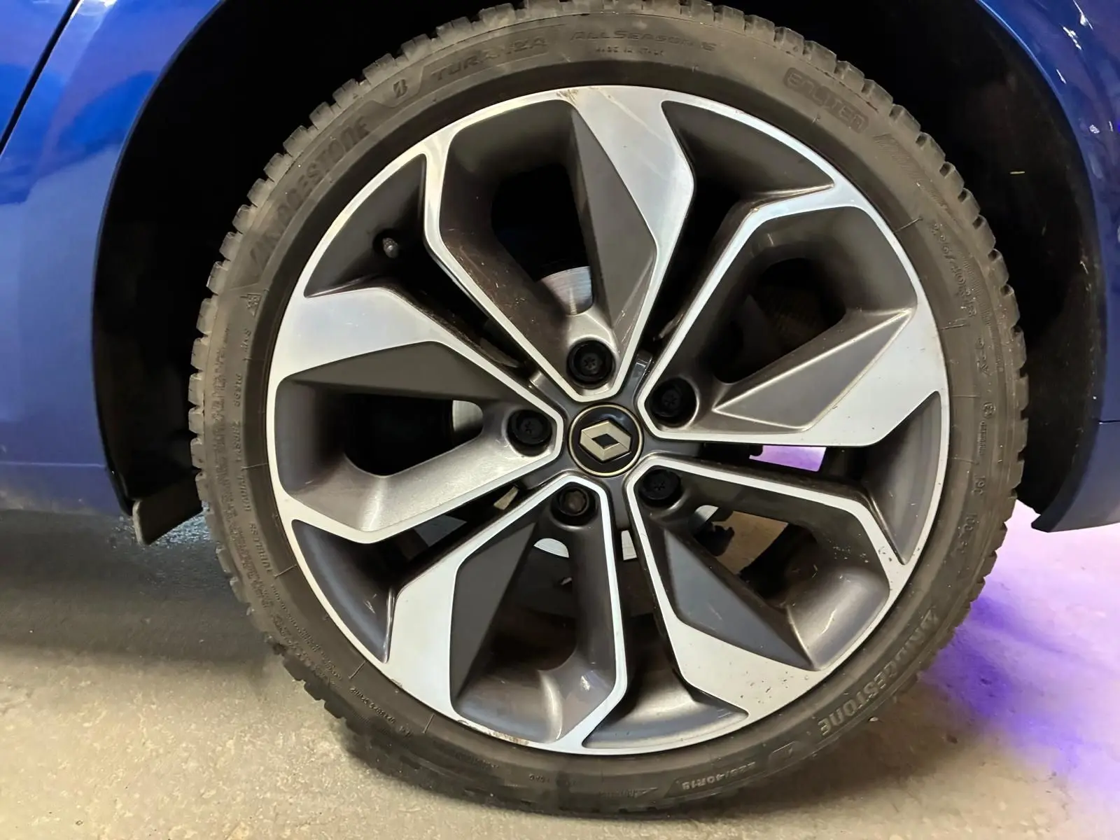 Gros plan sur la jante alliage 18 pouces au design moderne de la Renault Mégane bleu 2019.