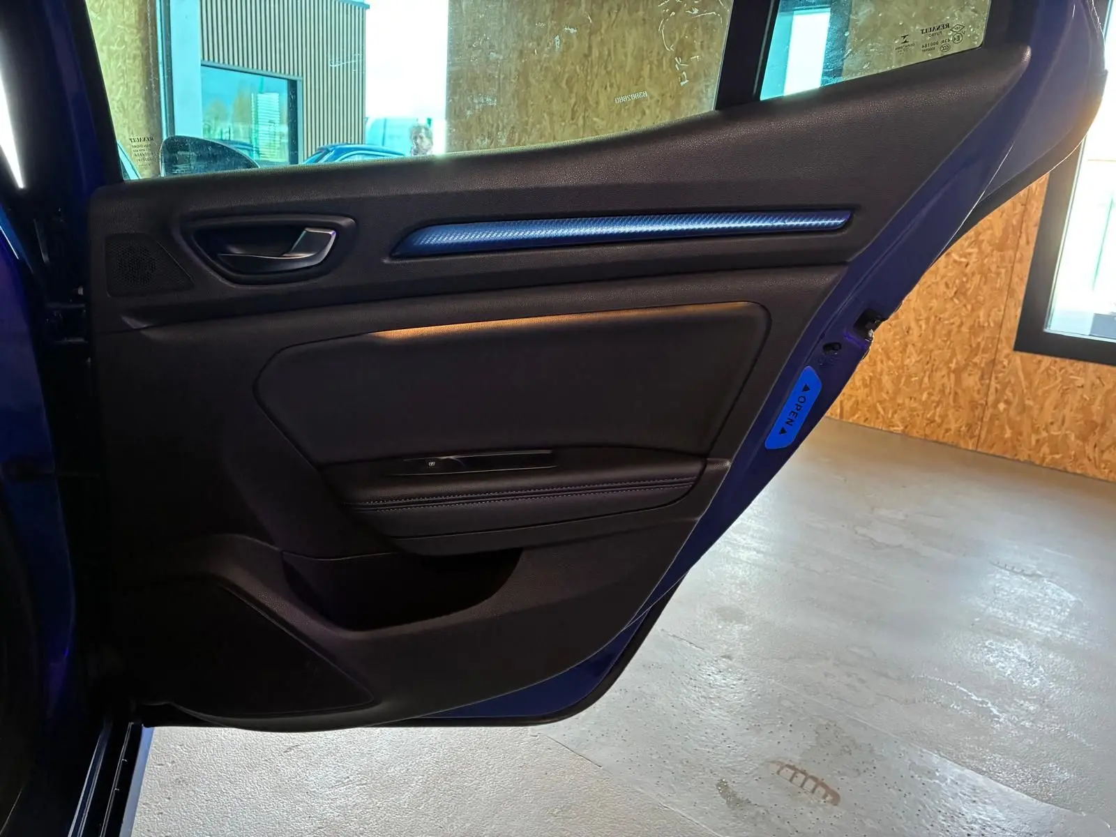 Vue intérieure de la porte arrière gauche bleu foncé de la Renault Mégane 1.7 BlueDCI GT Line avec garniture noire et insert décoratif bleu.