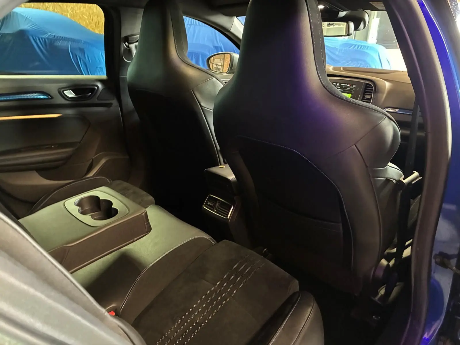 Vue intérieure arrière côté gauche d’une Renault Mégane 1.7 BlueDCI 150 GT Line bleue, avec sièges en cuir et alcantara noirs.