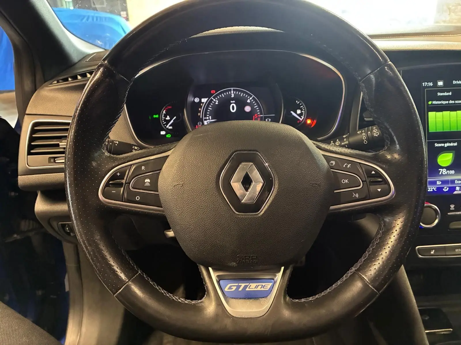 Vue rapprochée du volant cuir perforé noir avec logo Renault et badge GT Line, tableau de bord et écran tactile visibles.