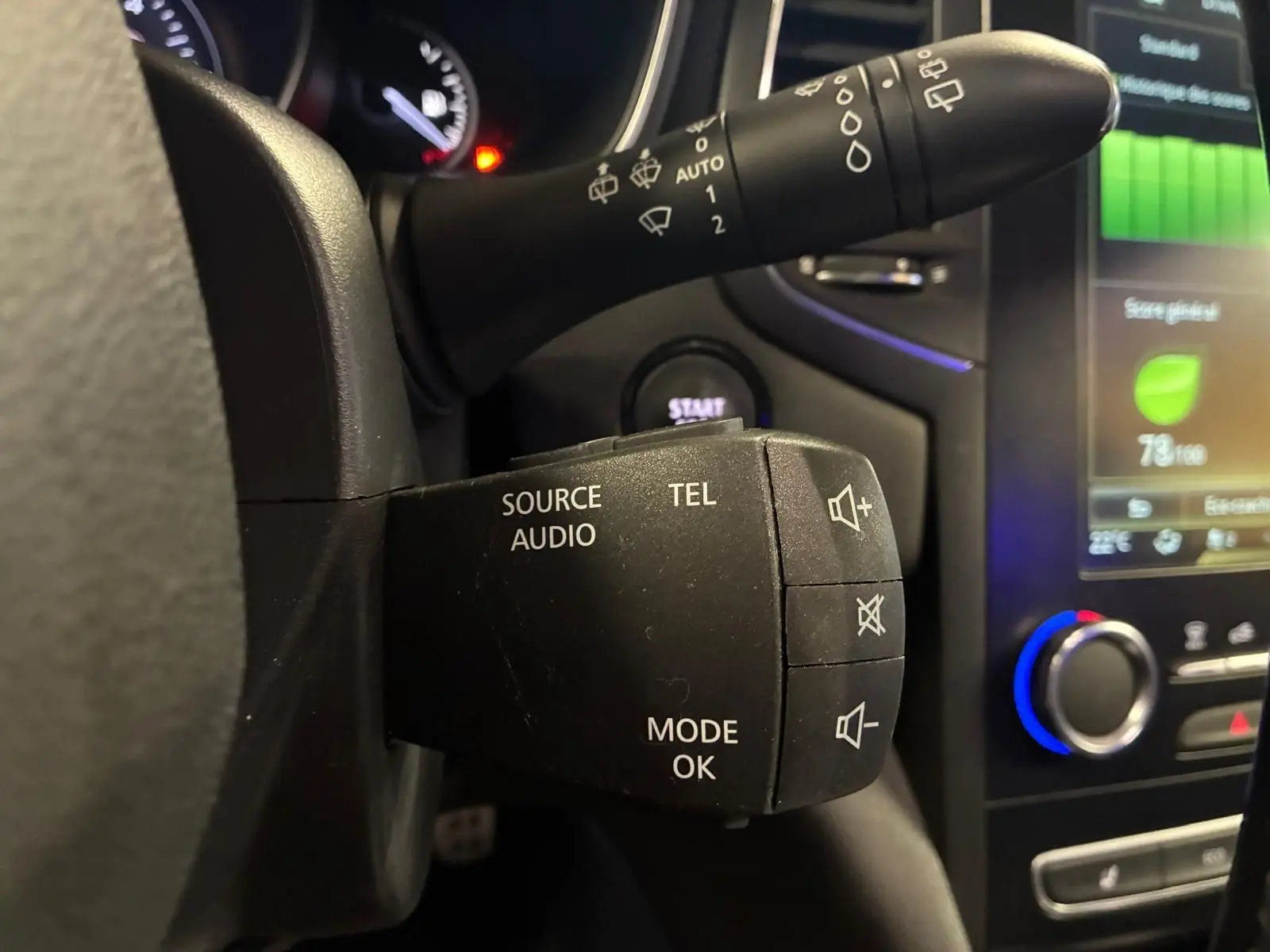 Gros plan sur la commande audio au volant de la Renault Mégane 1.7 BlueDCI 150 GT Line, intérieur noir avec écran tactile.