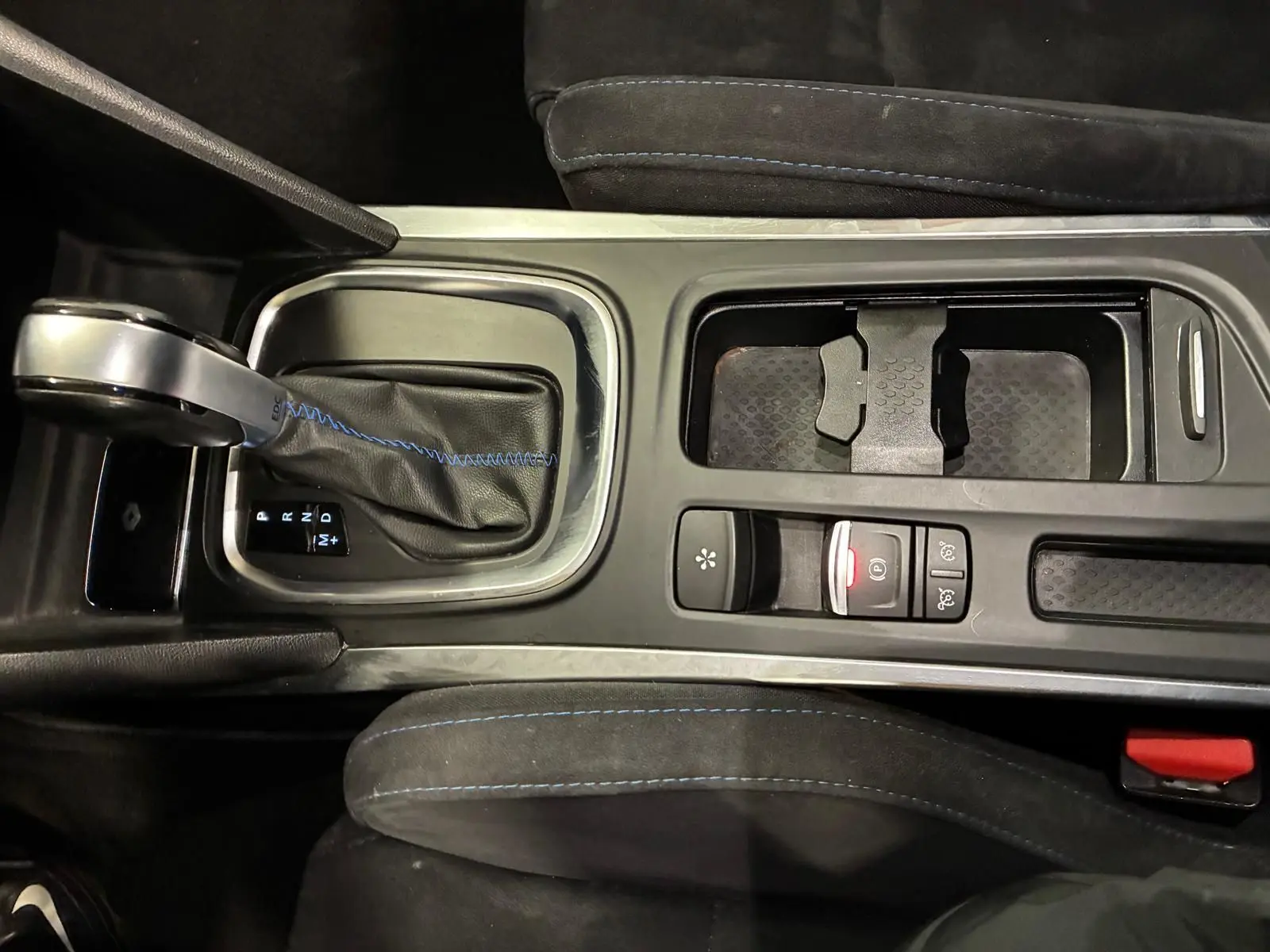 Vue plongeante sur la console centrale noire avec levier de vitesse automatique et surpiqûres bleues dans une Renault Mégane GT Line 2019.