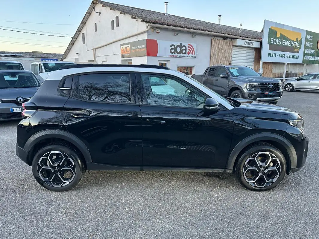 Profil côté gauche d'une Citroën C3 noire 2025 avec jantes alliage 17 pouces et toit blanc contrasté.