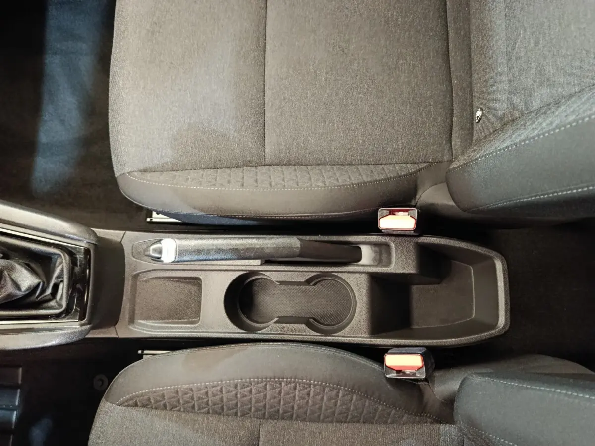 Vue plongeante sur la console centrale noire entre les sièges avant tissu gris foncé de la Renault Clio Business Blue dCi 100.