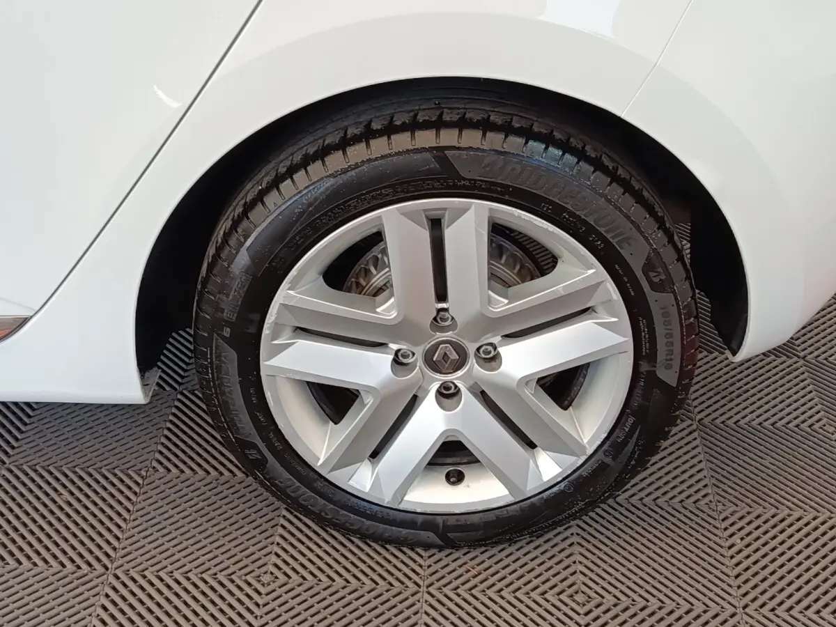 Gros plan sur la roue arrière droite d'une Renault Clio Business Blue dCi 100 blanche, avec passage de roue et partie de la carrosserie visibles.