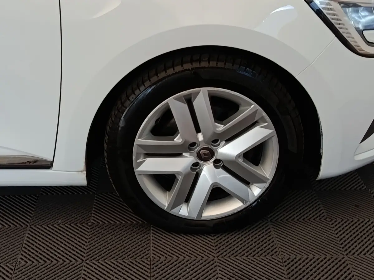 Gros plan sur la roue avant droite d’une Renault Clio Business Blue dCi 100 blanche avec jante alliage moderne.