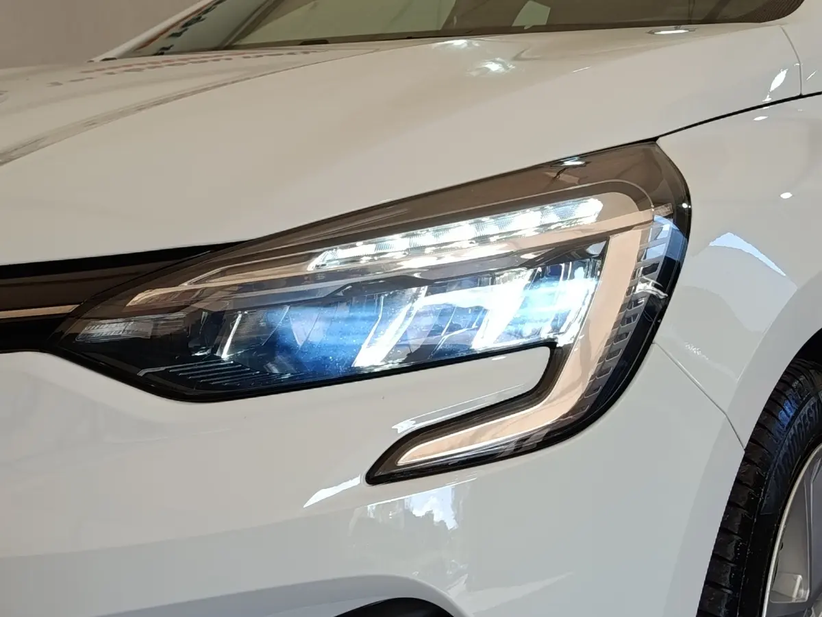 Gros plan sur le phare avant droit LED d’une Renault Clio Business Blue dCi 100 blanche de 2022.