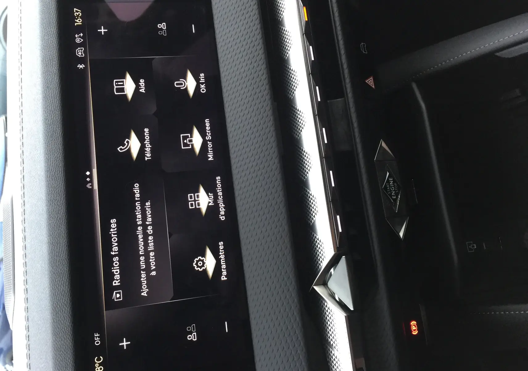 Vue rapprochée de la console centrale noire du DS4 2024 avec écran tactile et bouton démarrage stylisé diamant