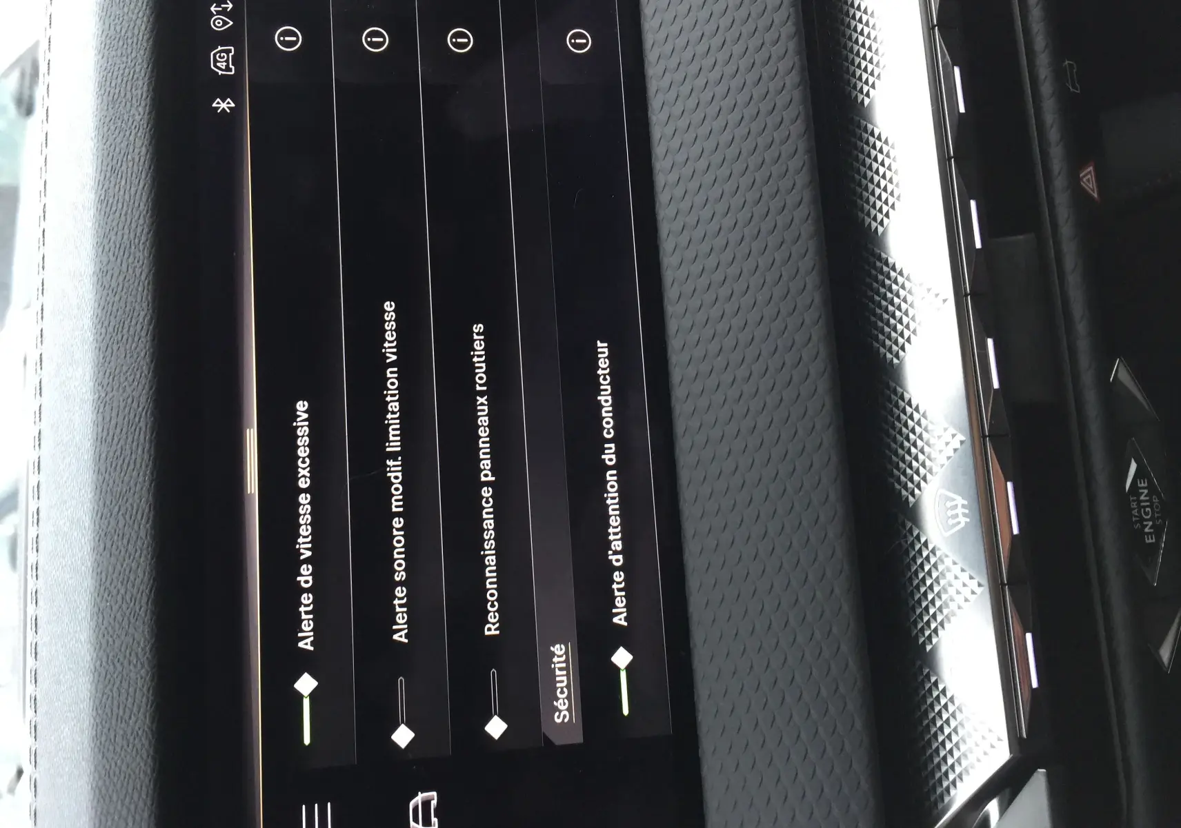 Vue rapprochée de l’écran tactile intérieur du DS4 2024 affichant les alertes de sécurité sur un tableau de bord texturé gris.