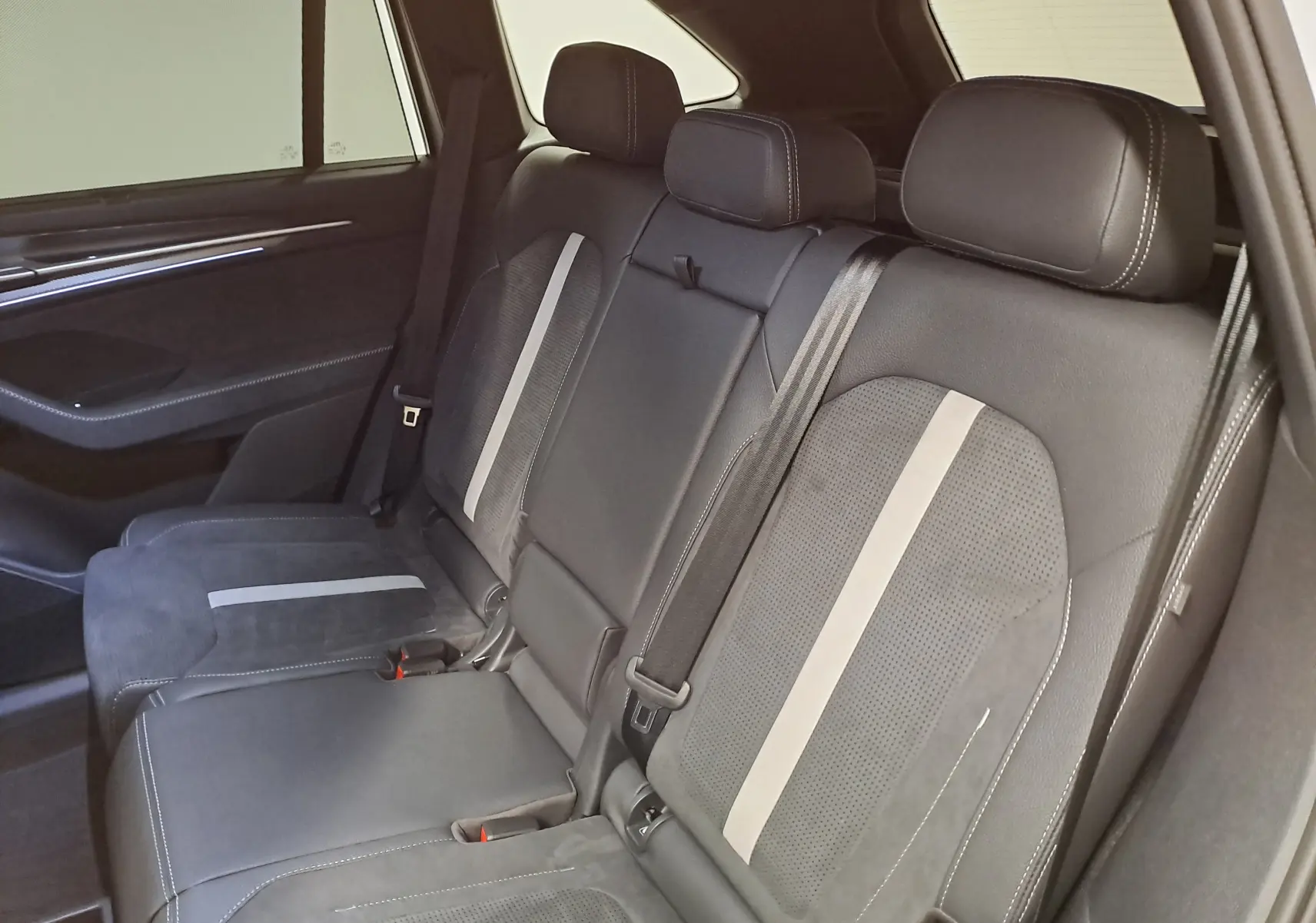 Vue intérieure des sièges arrière en cuir noir avec bandes grises du Skoda Kodiaq 2025, version Sportline.